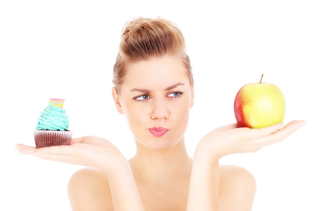 Woman holding an apple and cupcake