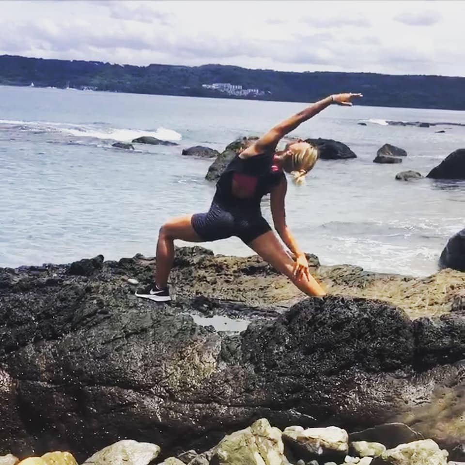 Emily Audibert doing yoga on the beach